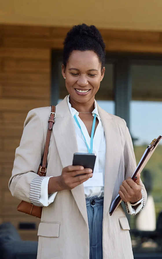 Property manager outside the Bayside Retreat, filing a walkthrough report from their phone
