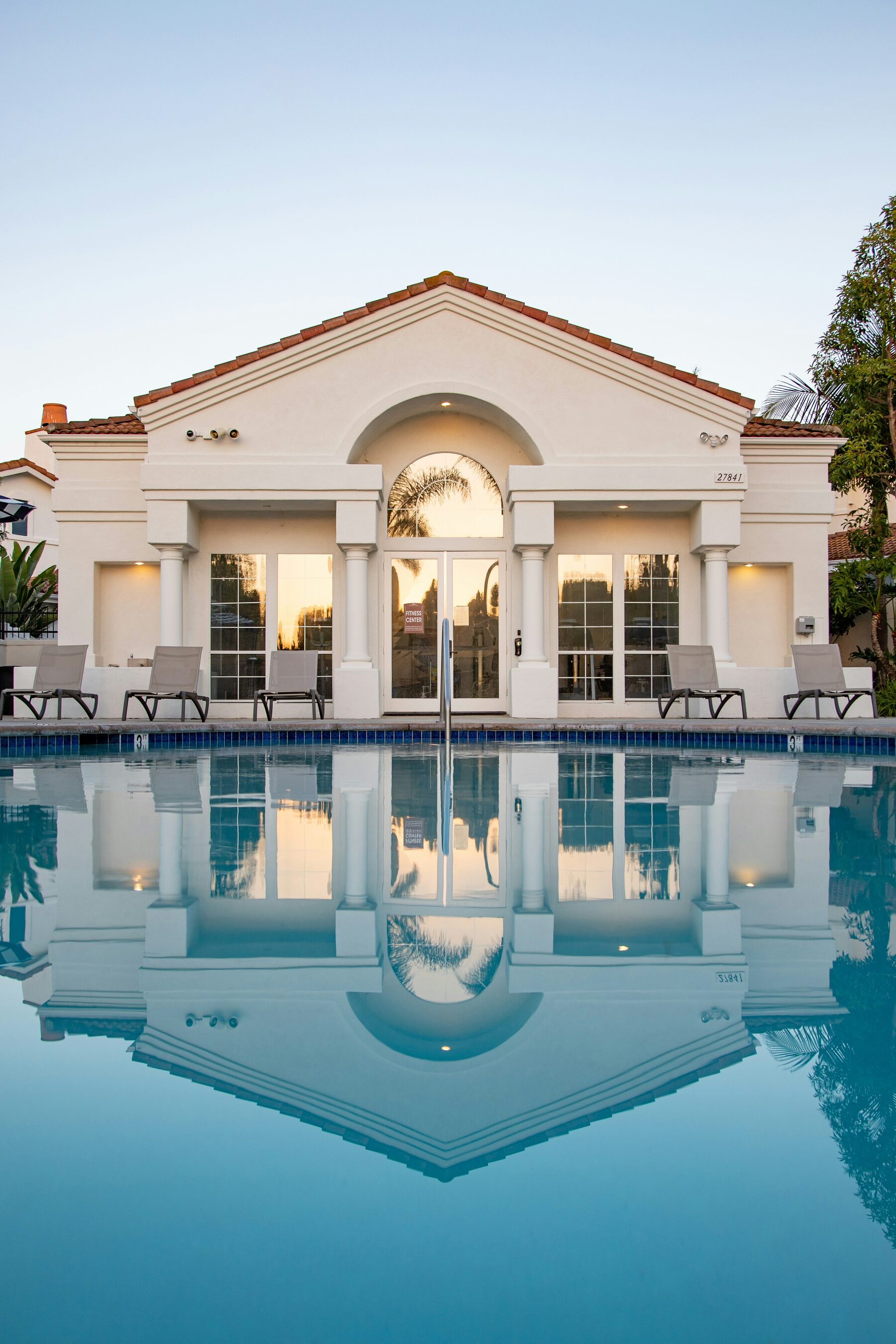Luxury estate clubhouse lit at dusk, prepared and staffed ahead of guest arrival