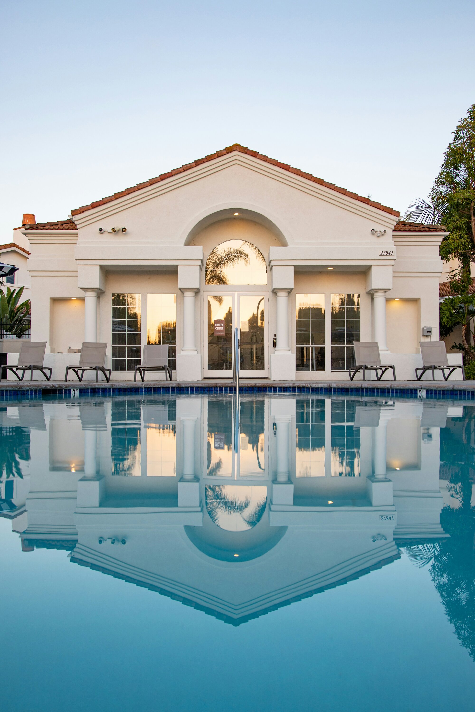 Poolside clubhouse terrace at a luxury estate, prepared and lit for guest arrival